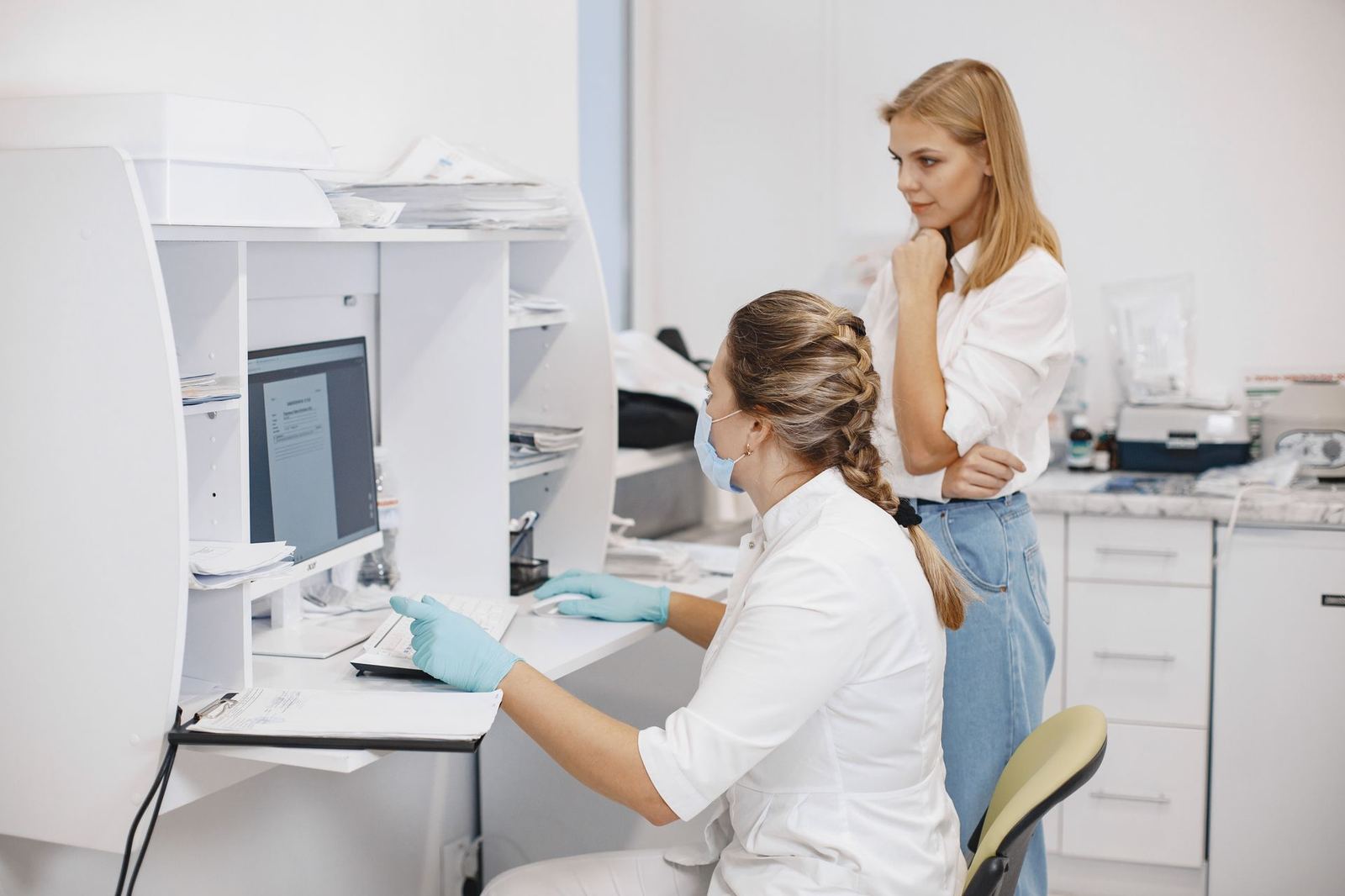 Healthcare professionals reviewing operational information at a clinic workstation